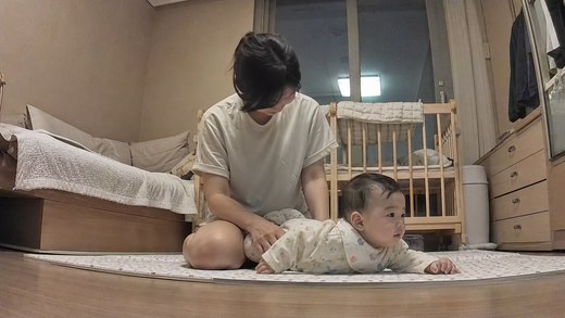 Mia on the play mat with a parent beside her.